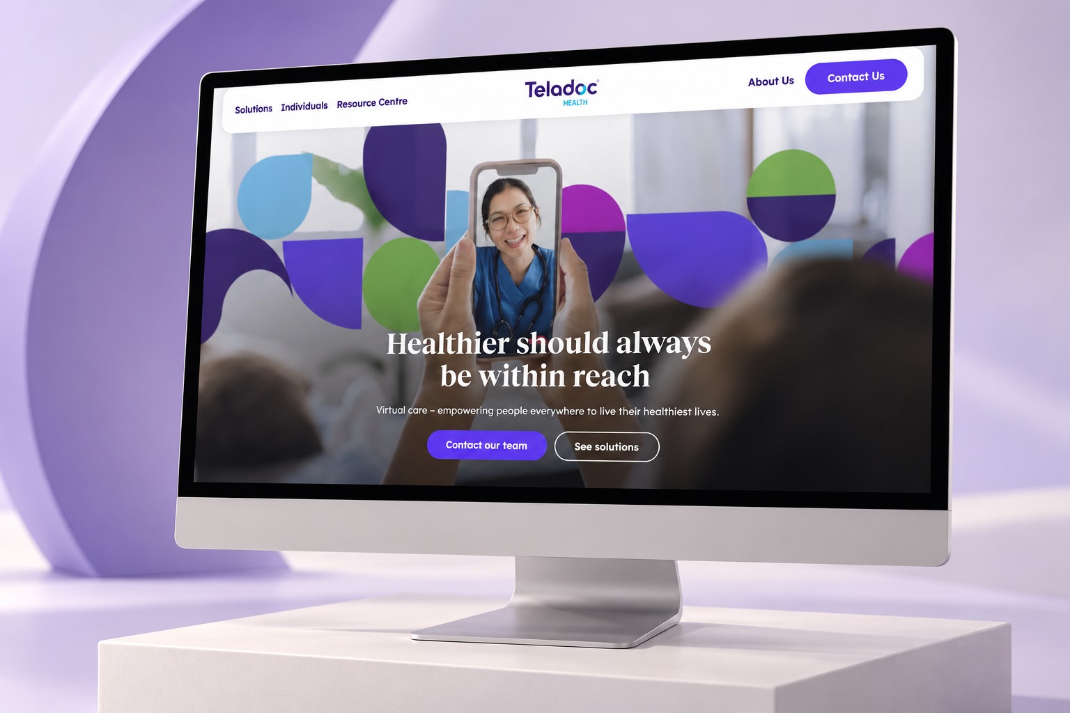 Teladoc Health homepage displayed on a desktop monitor in a lavender studio